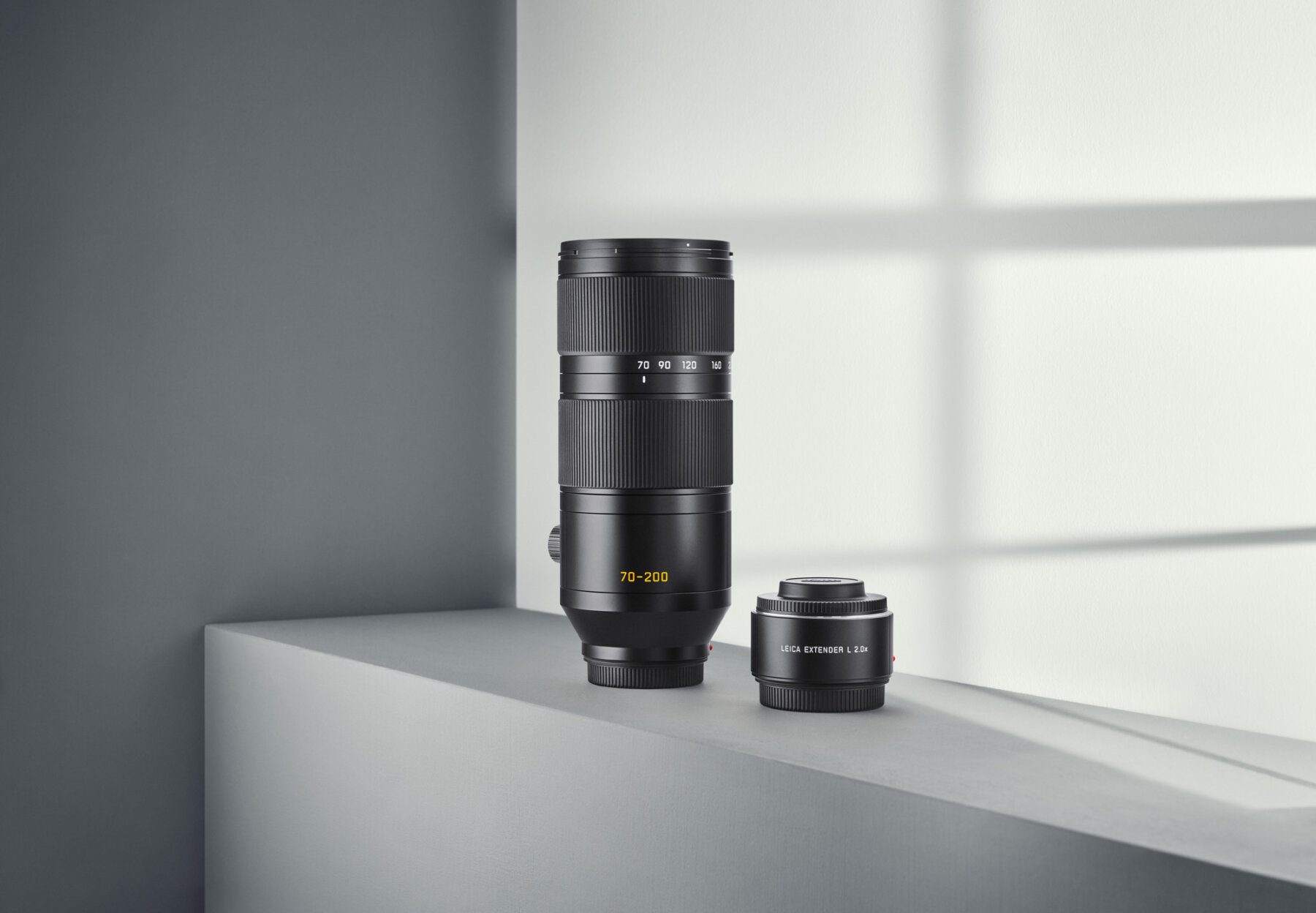 Two Leica photo lenses stand on a still life photo set