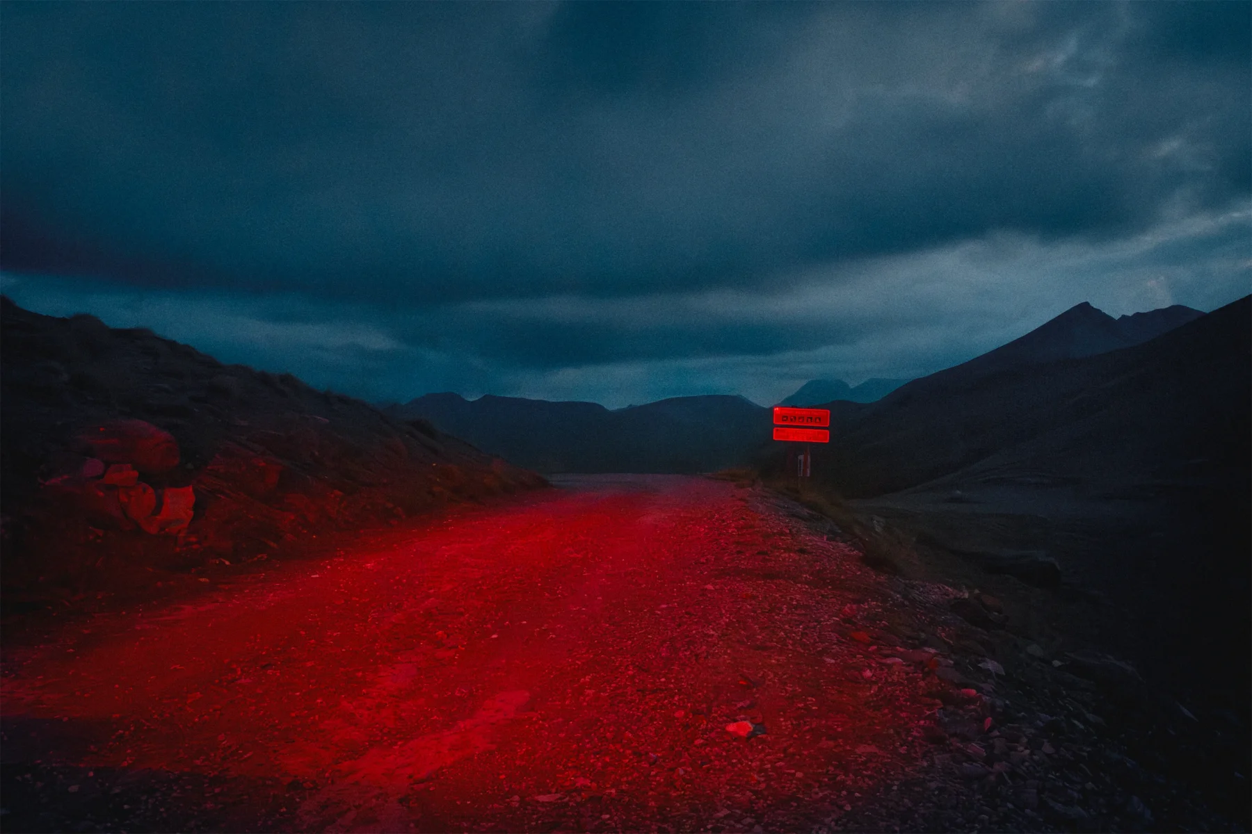 Gravelroad in red rear lights, Maritime Alps