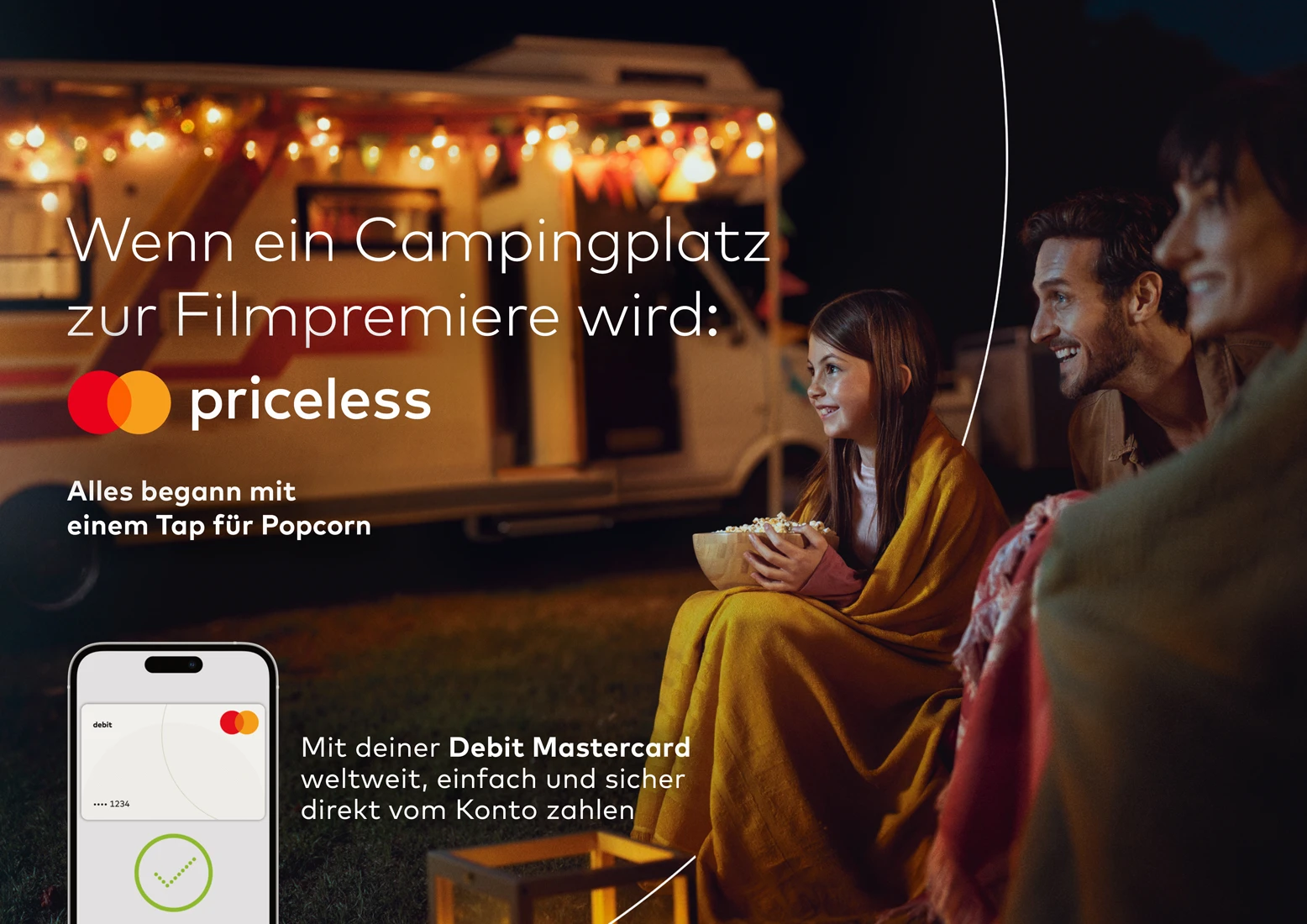 a family watches a movie outdoor in front of their caravan