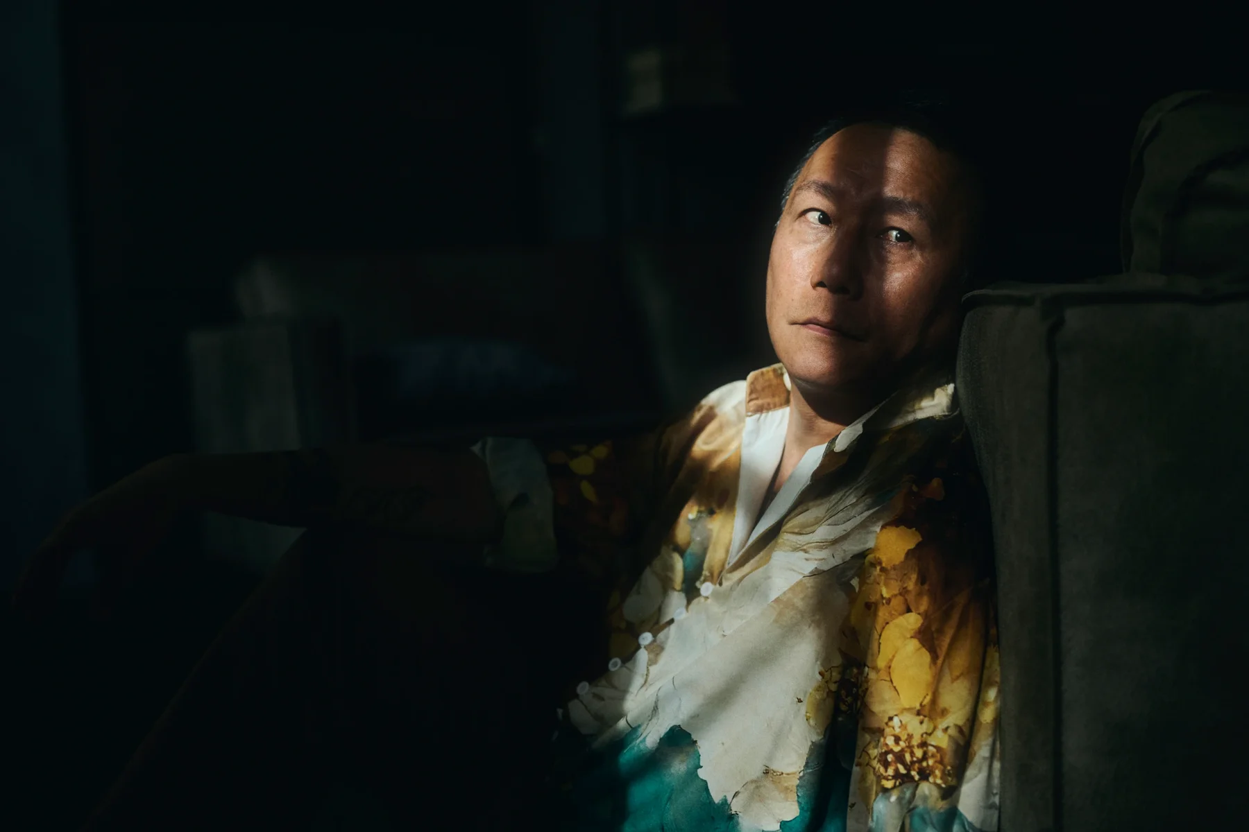 portrait of a man leaning against a couch