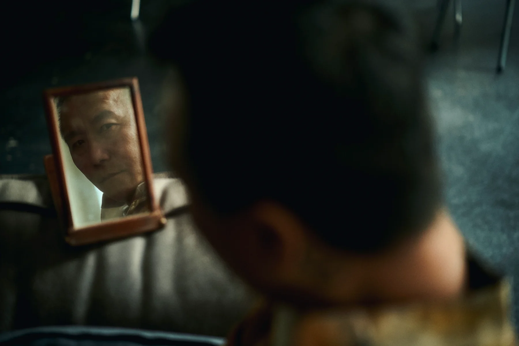 a man watches his reflection in a mirror