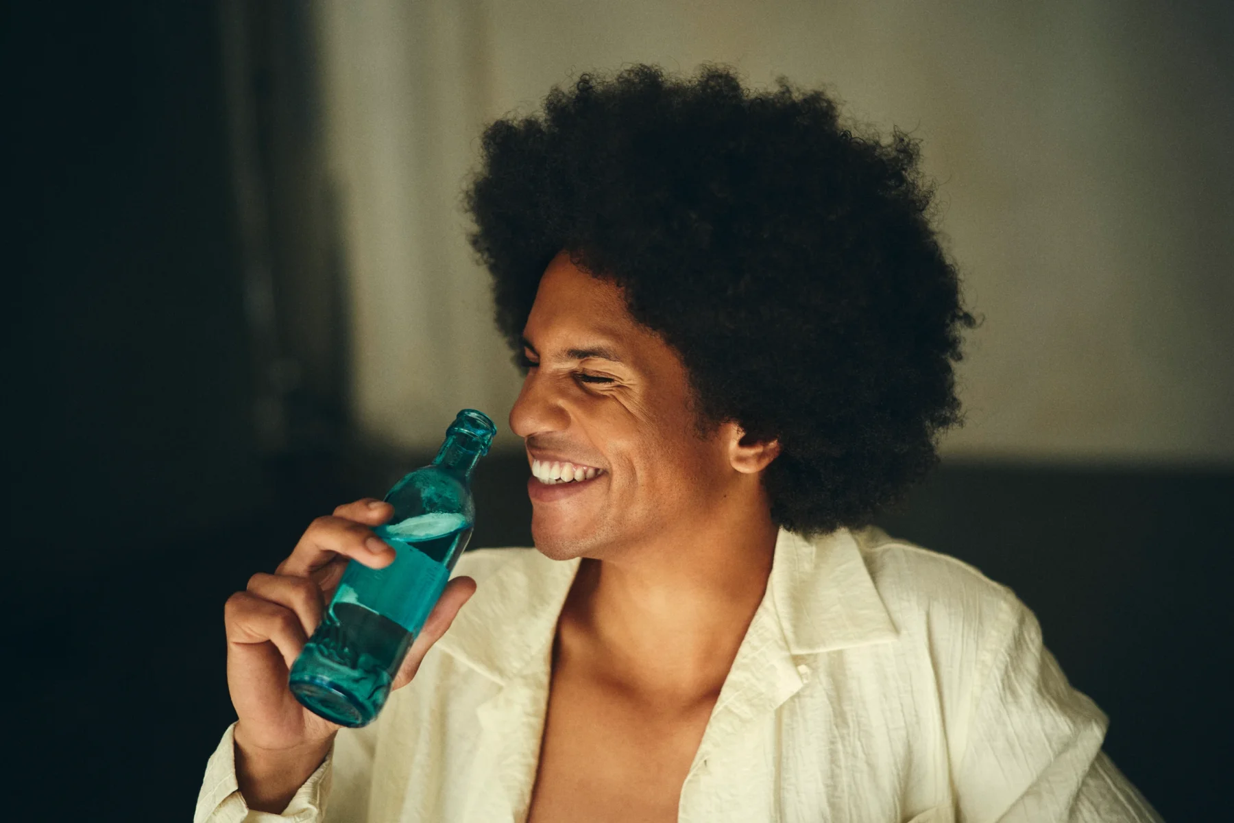 portrait of a smiling man drinking out of a water bottle