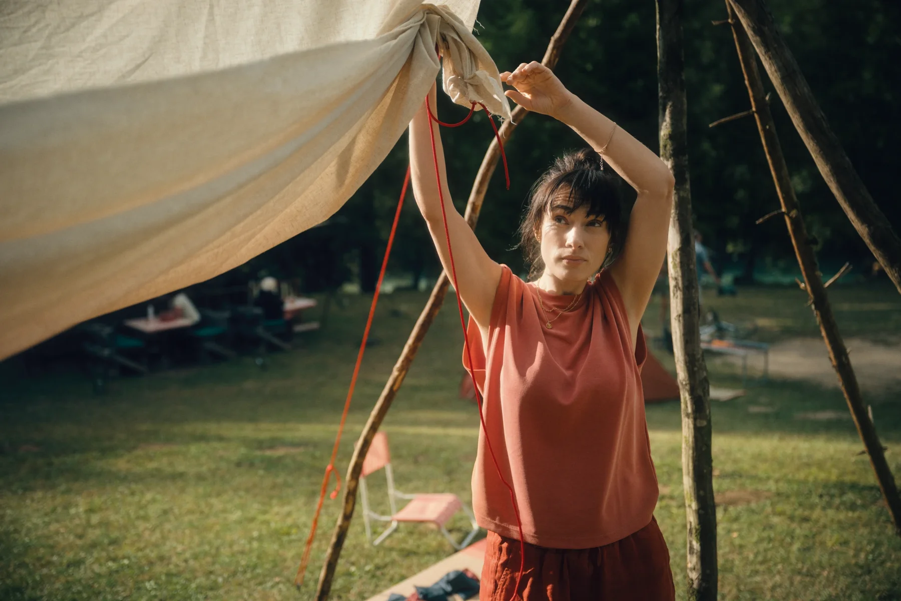 a woman holds a fabric sheet while building an outdoor cinema