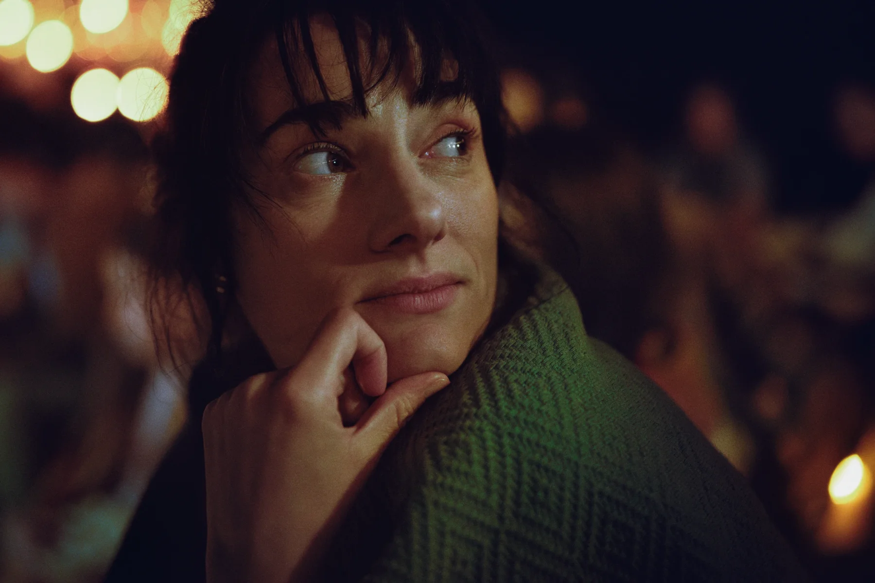 portrait of a woman looking over her shoulder while watching a movie outdoors