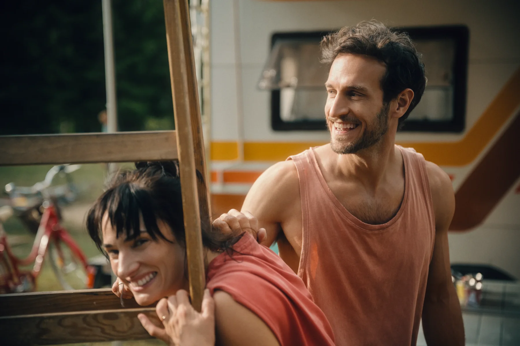 man and woman having fun while building an outdoor cinema